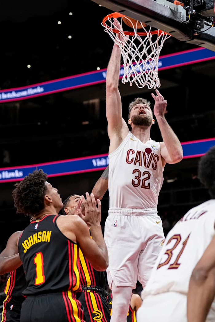 Jan 20, 2024; Atlanta, Georgia, USA; Cleveland Cavaliers forward Dean Wade (32) scores a basket over Atlanta Hawks forward Jalen Johnson (1) during the first half at State Farm Arena.